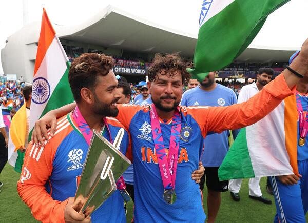 Rishabh Pant and Kuldeep Yadav pose with the trophy as Team India celebrate after winning the T20 World Cup.