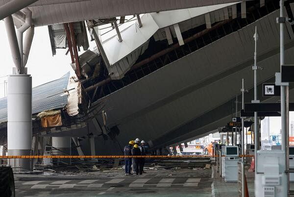 Officials from the Delhi Forensic Science Laboratory stand next to a portion of a canopy that collapsed following heavy rains at the Indira Gandhi International Airport in New Delhi, India, June 28, 2024.