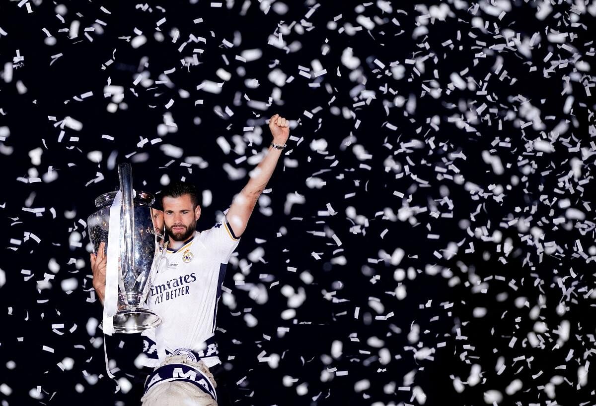 Real Madrid's Nacho celebrates with the trophy after placing the traditional scarf at the Fuente de las Cibeles after winning the Champions League.