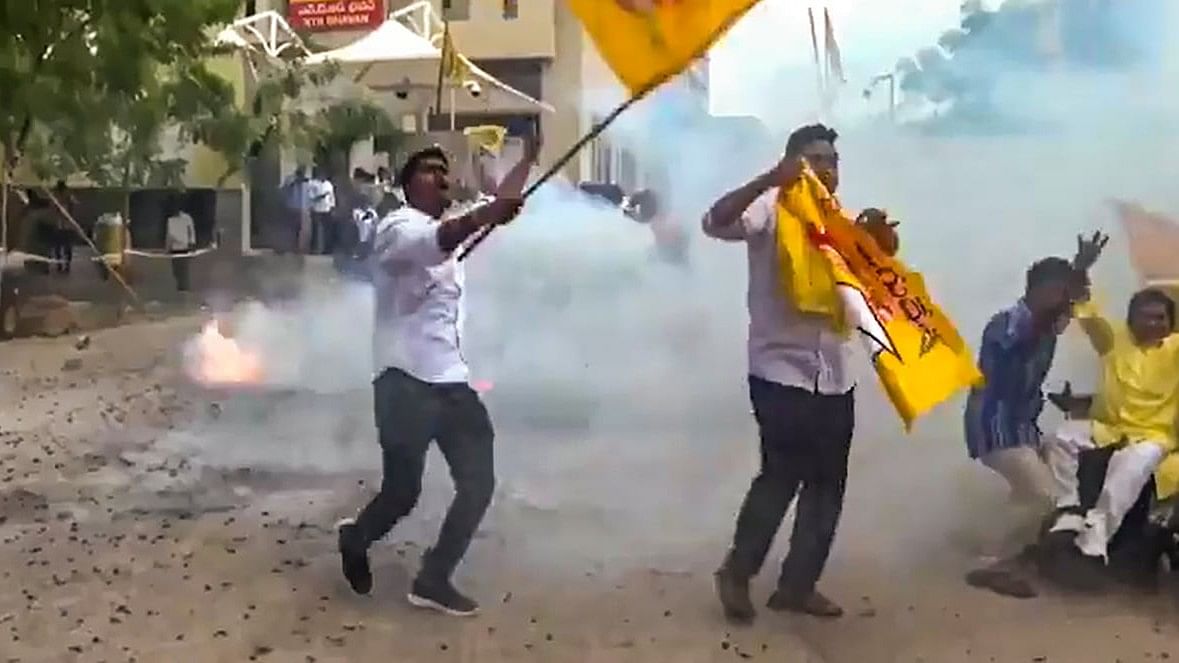 TDP supporters burst crackers as they celebrate their party's performance in the Assembly polls, at the party central office, in Guntur.