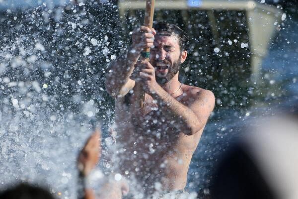 Max Allen swims to shore and is celebrated during the Greasy Pole contest at St. Peter's Fiesta, honoring the patron saint of the local fisherman, in Gloucester, Massachusetts, U.S.