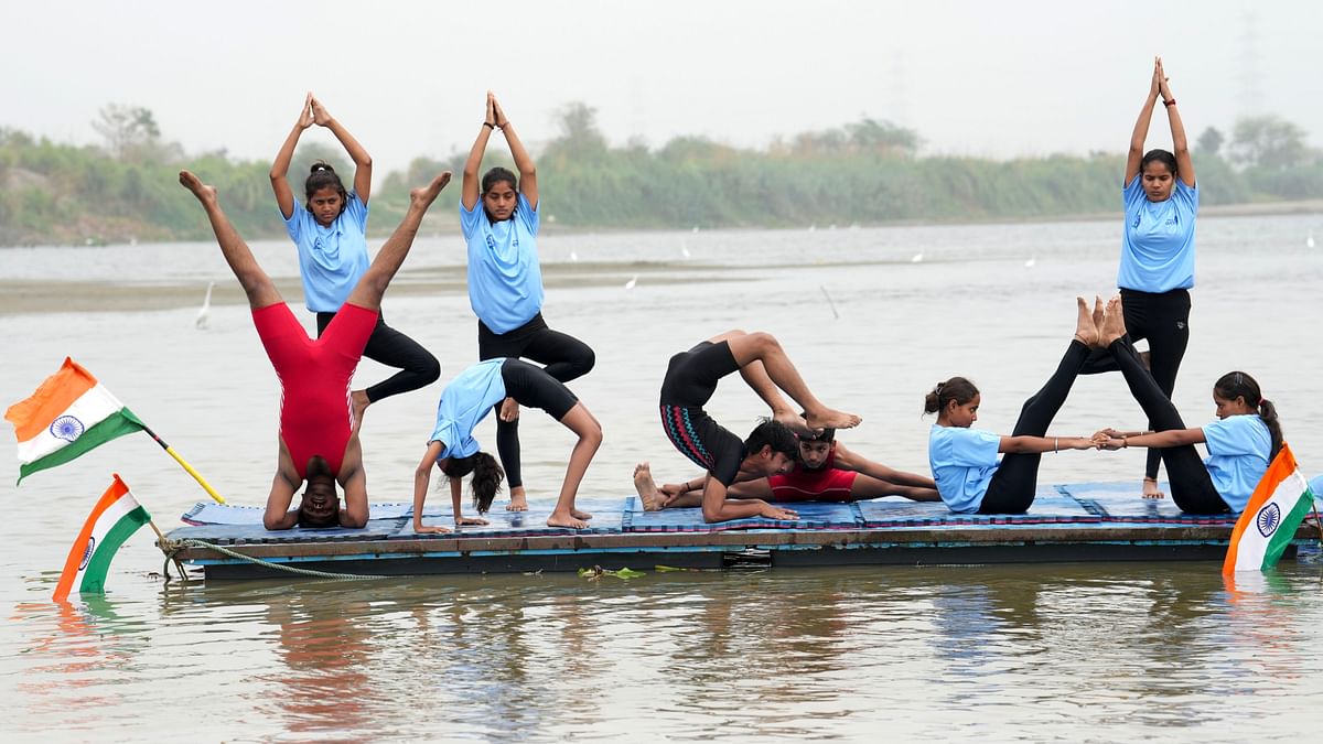 People perform yoga on the Yamuna river at Sonia Vihar during celebrations on the 10th International Day of Yoga, in New Delhi.