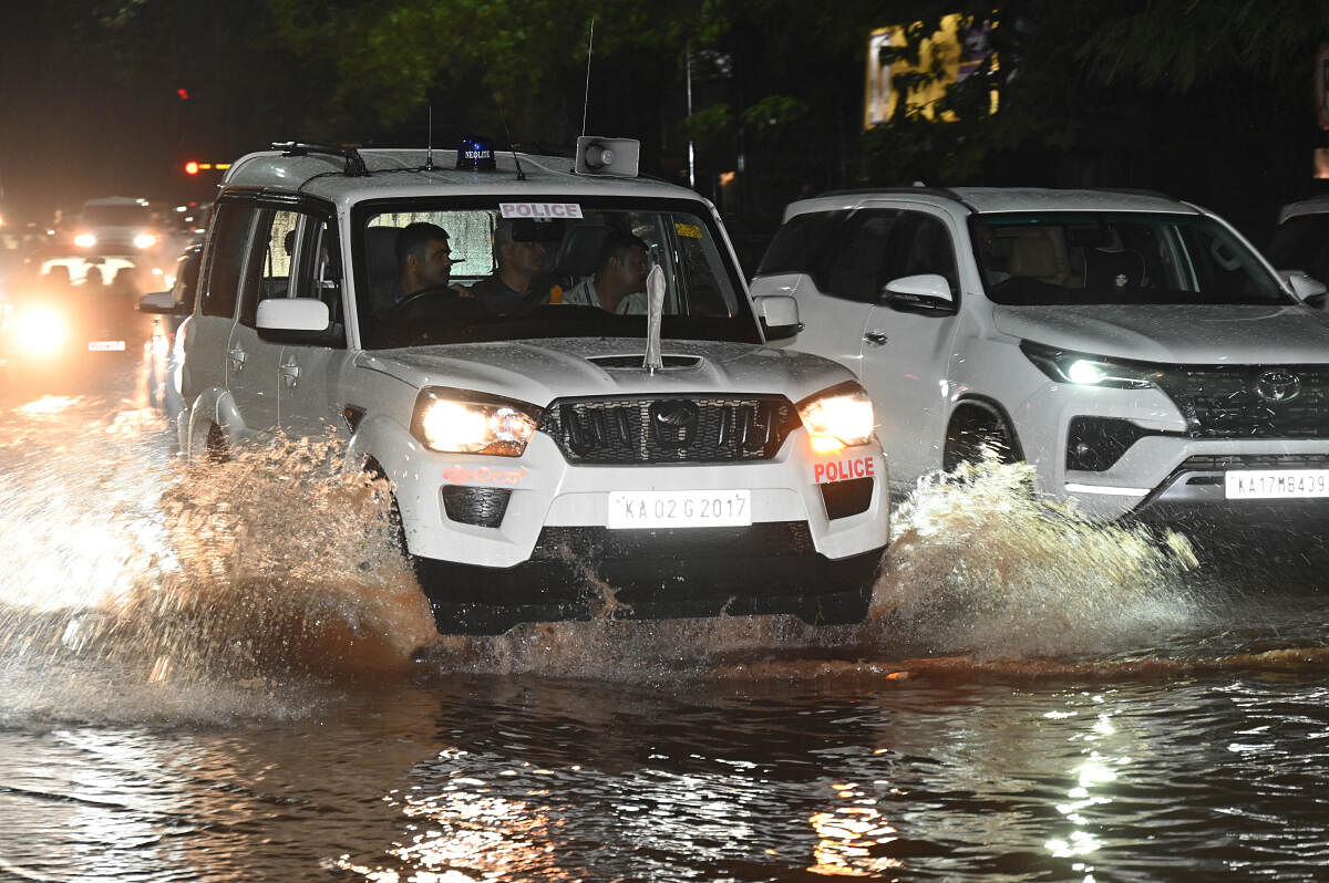 Motorists are vehicle wades through a waterlogged road during heavy rainfall in Bengaluru on Sunday. 