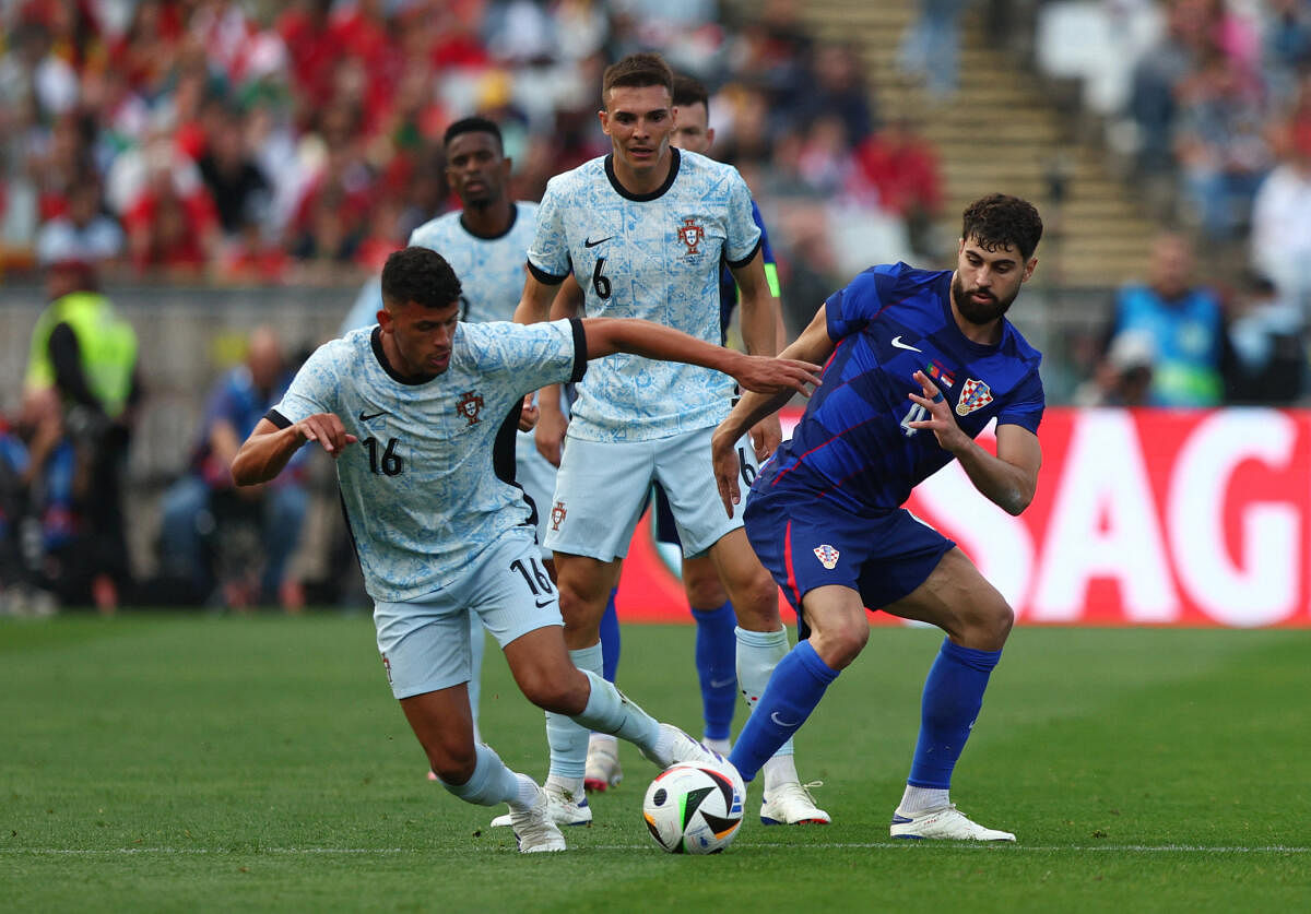 Croatia's Josko Gvardiol defending the ball against Portugese players.