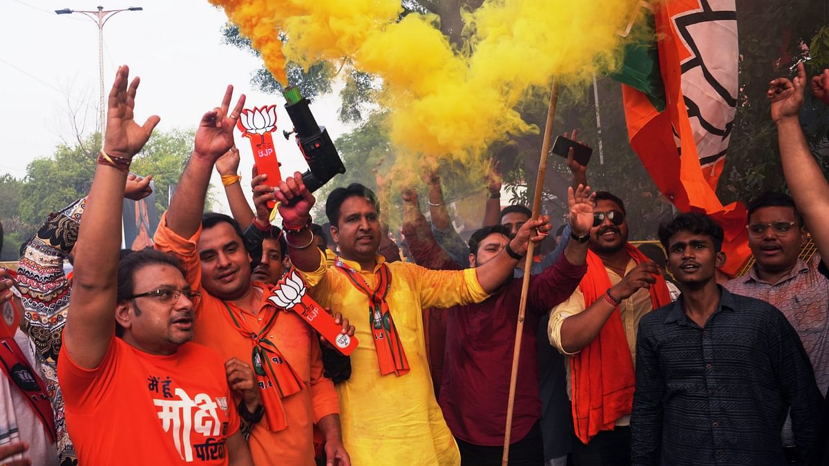 Supporters celebrate during the arrival of Prime Minister Narendra Modi for a meeting at BJP headquarters as the party leads in the Lok Sabha elections amid the counting of votes, in New Delhi.
