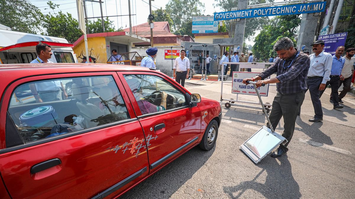 A security personnel checks a vehicle outside a counting centre, a day before counting of votes for the Lok Sabha elections, in Jammu.