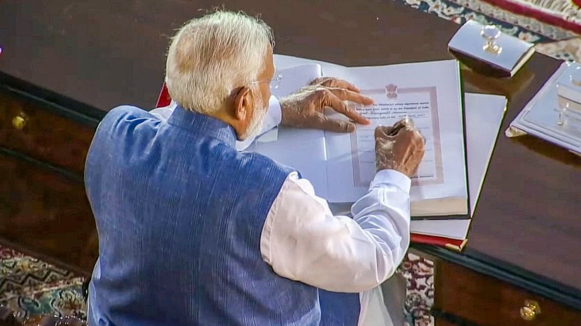 PM-designate Narendra Modi signs the copy after taking oath as Prime Minister for the third consecutive term, at Rashtrapati Bhavan in New Delhi.