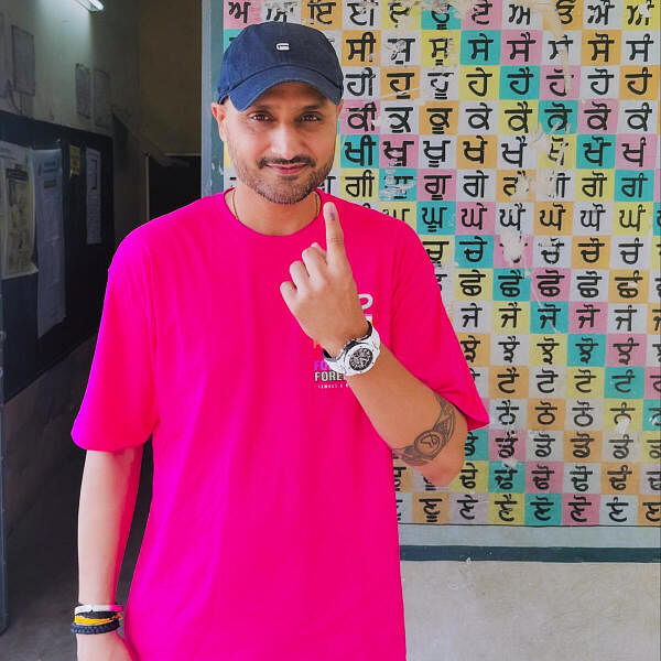 Former cricketer Harbhajan Singh shows his inked finger after casting his vote at a polling booth  in Jalandhar.