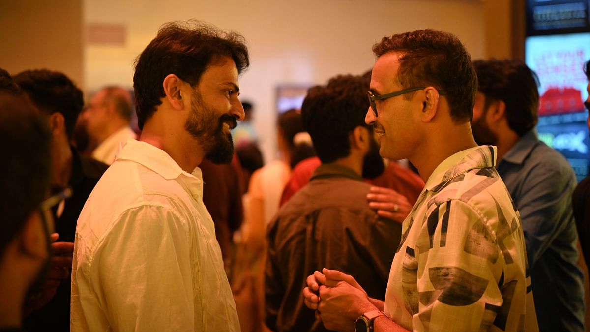 Daali Dhananjaya is seen engrossed in a deep conversation with Parameshwar Gundkal during the premiere of Kotee in Bengaluru.