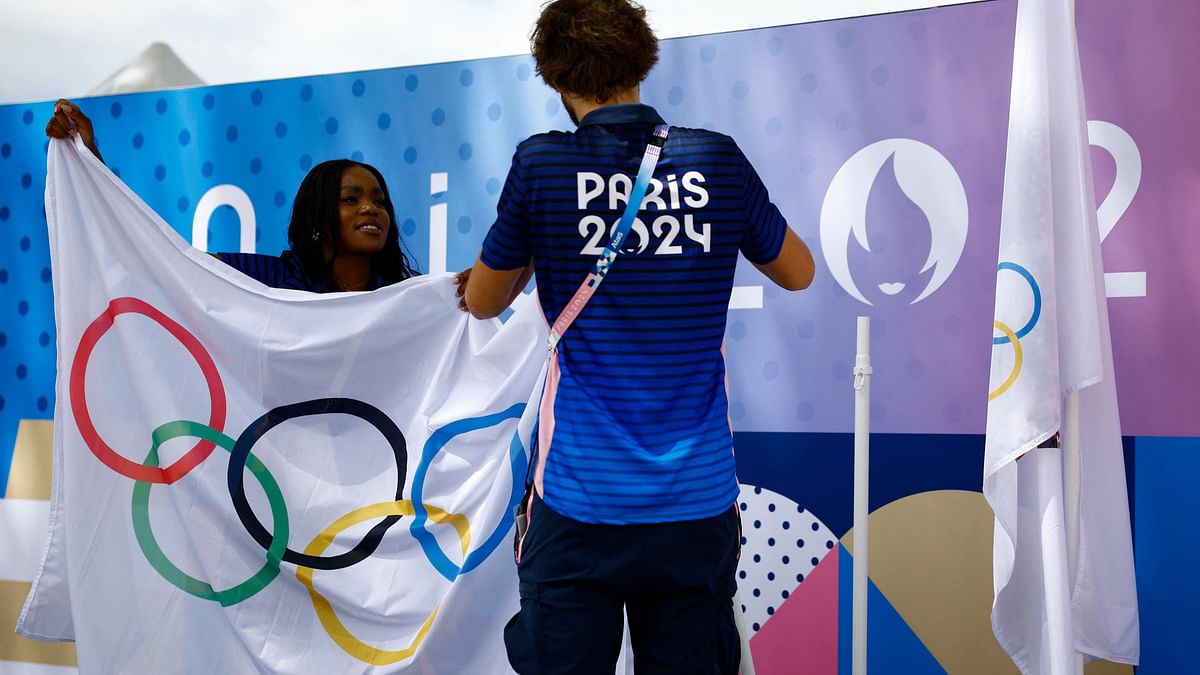 Workers prepare the Olympics flag ahead of the event in Paris.