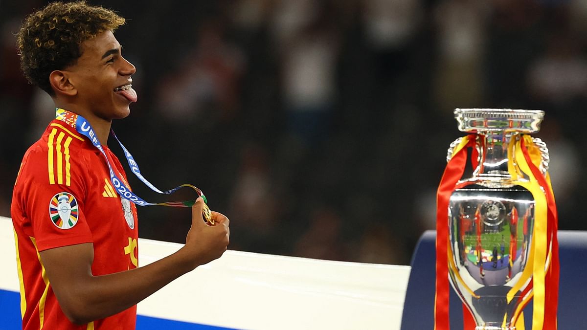 Spain's Lamine Yamal walks past the trophy after collecting his winner's medal.