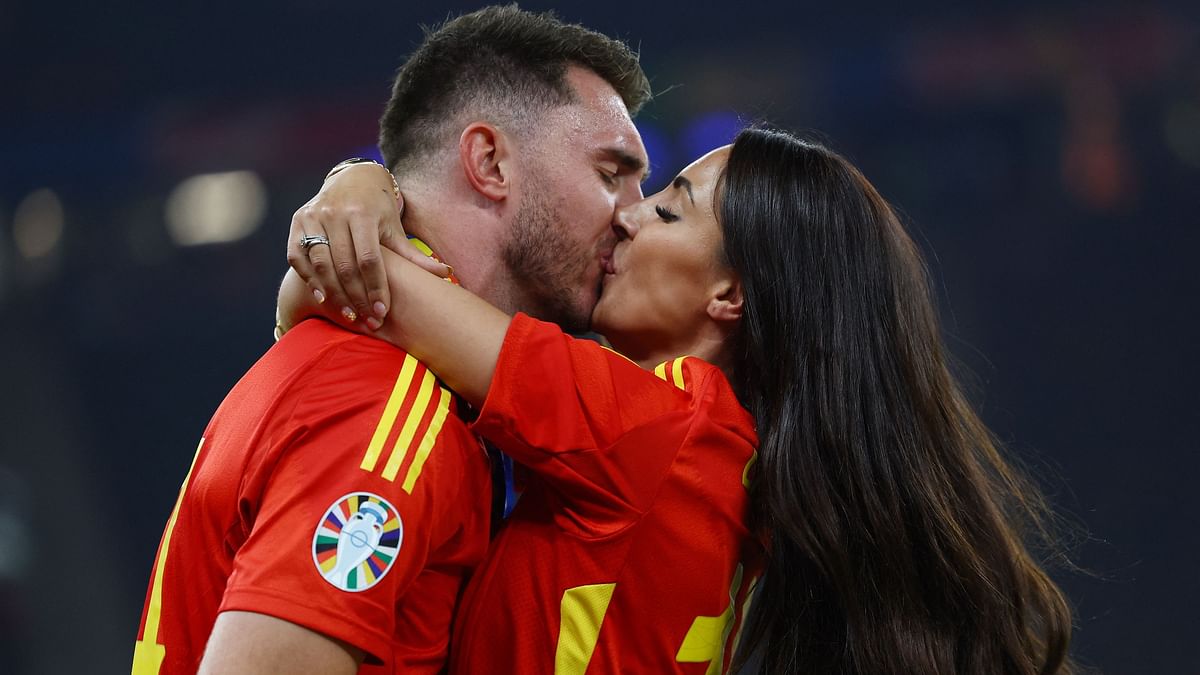 Spain's Aymeric Laporte kisses his fiancee Sara Botello as they celebrate Euro 2024 victory.