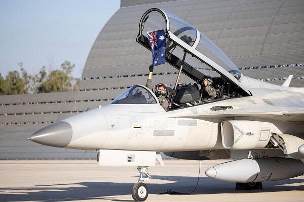 A Philippine Air Force FA-50PH pilot holds an Australian flag after arriving at RAAF Base Darwin, ahead of the Exercise Pitch Black war games, in Australia.