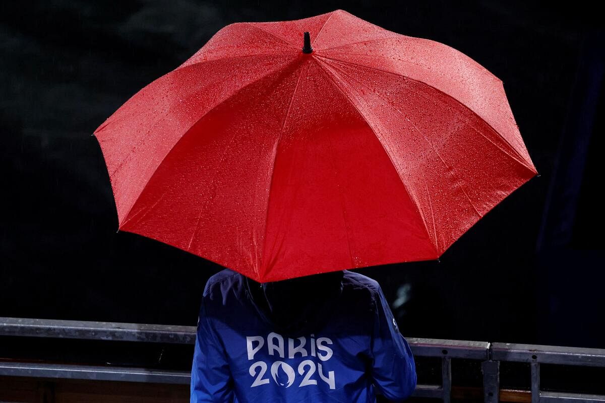 A volunteer holds an umbrella during the opening ceremony of the Paris 2024 Olympic Games.