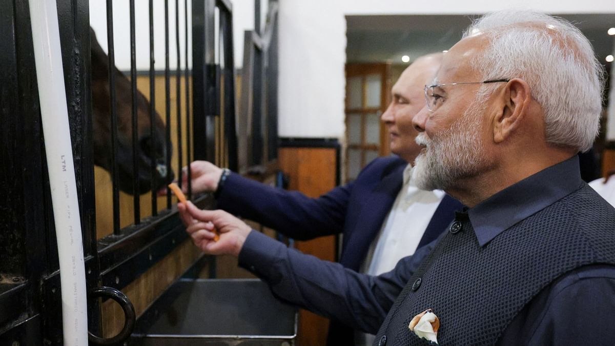 Vladimir Putin and Narendra Modi visit a horse barn during their meeting at the Novo-Ogaryovo state residence near Moscow, Russia.