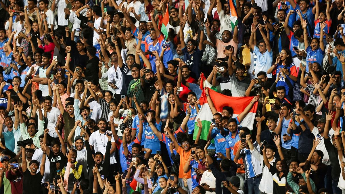 Fans celebrate as they watch the Indian cricket team players take a victory lap around the Wankhede stadium after winning the ICC men's T20 World Cup, in Mumbai.