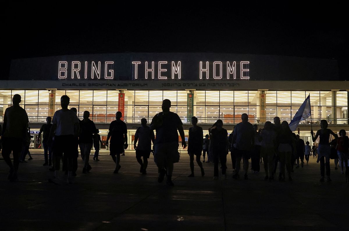 People walk in front of the Charles Bronfman Auditorium, as they attend a demonstration against Israeli Prime Minister Benjamin Netanyahu's government and a call for the release of hostages in Gaza, amid the Israel-Hamas conflict, in Tel Aviv, Israel, July 13, 2024.