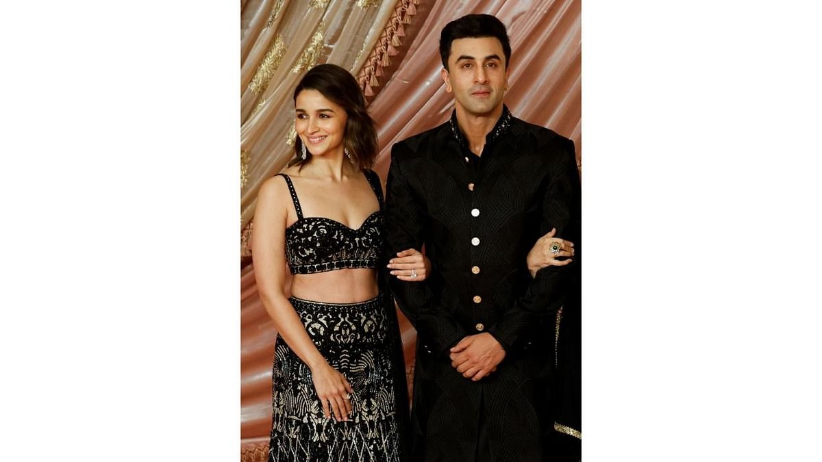 Alia Bhatt and Ranbir Kapoor pose for a picture on the red carpet during the Sangeet ceremony.