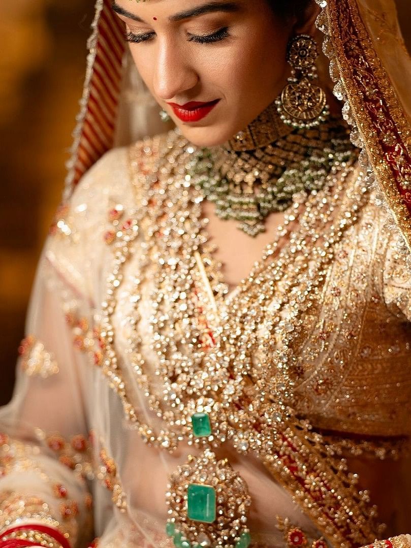 The head veil has impossibly delicate jaali and cut-work while the detachable trail is a Zardozi marvel of 80 inches.