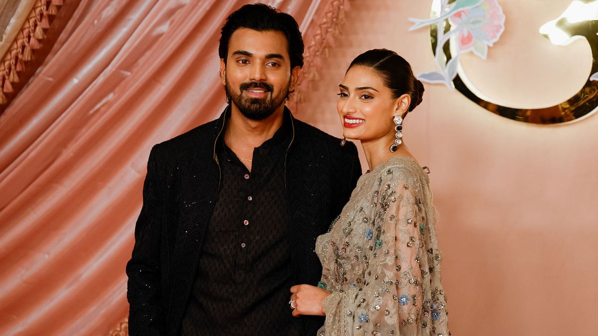 Cricketer KL Rahul and actress Athiya Shetty pose on the red carpet during the Sangeet ceremony.