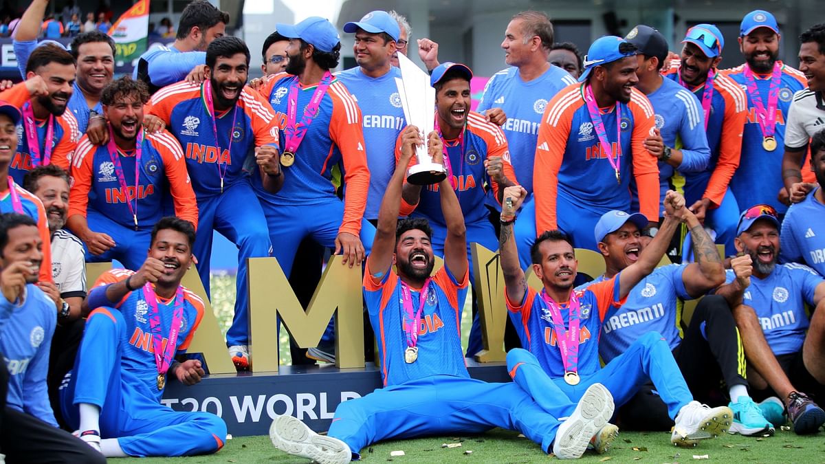 Mohammed Siraj holding the coveted trophy aloft, surrounded by his jubilant teammates.