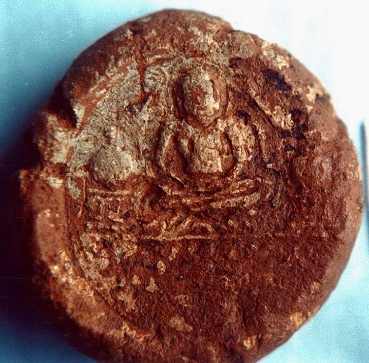 A clay medallion with a Buddha figure. 