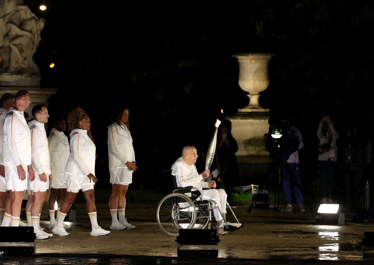  Former French Olympian Charles Coste passes the torch to Teddy Riner and Marie-Jose Perec.