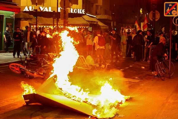 A barricade burns as protesters demonstrate against the French far-right Rassemblement National (National Rally - RN) party, following partial results in the first round of the early 2024 legislative elections, at the Place de la Republique in Paris, France, July 1, 2024.