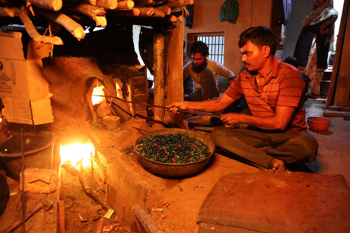 Glass bangle pieces being placed in the furnace to be melted down.