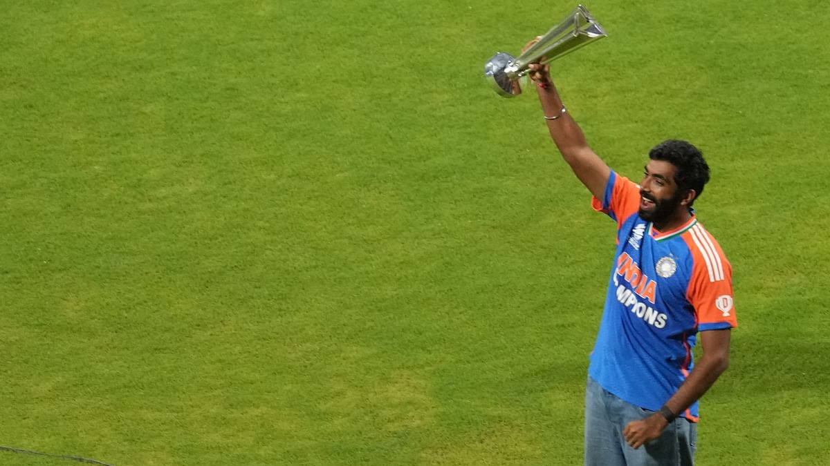 Jasprit Bumrah holds the championship trophy during a felicitation ceremony at the Wankhede Stadium, in Mumbai.
