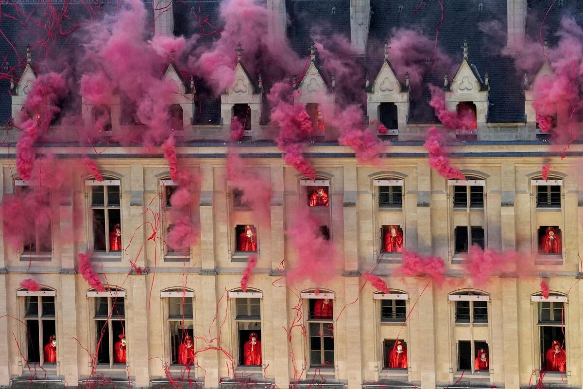 Smoke billows near windows as performers participate during the opening ceremony.