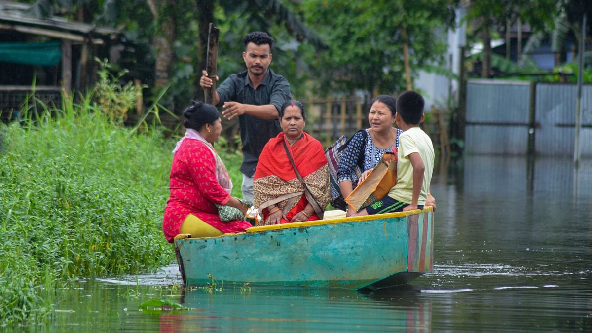 Residents use a boat to travel in a flooded area after heavy rainfall, in Dibrugarh.