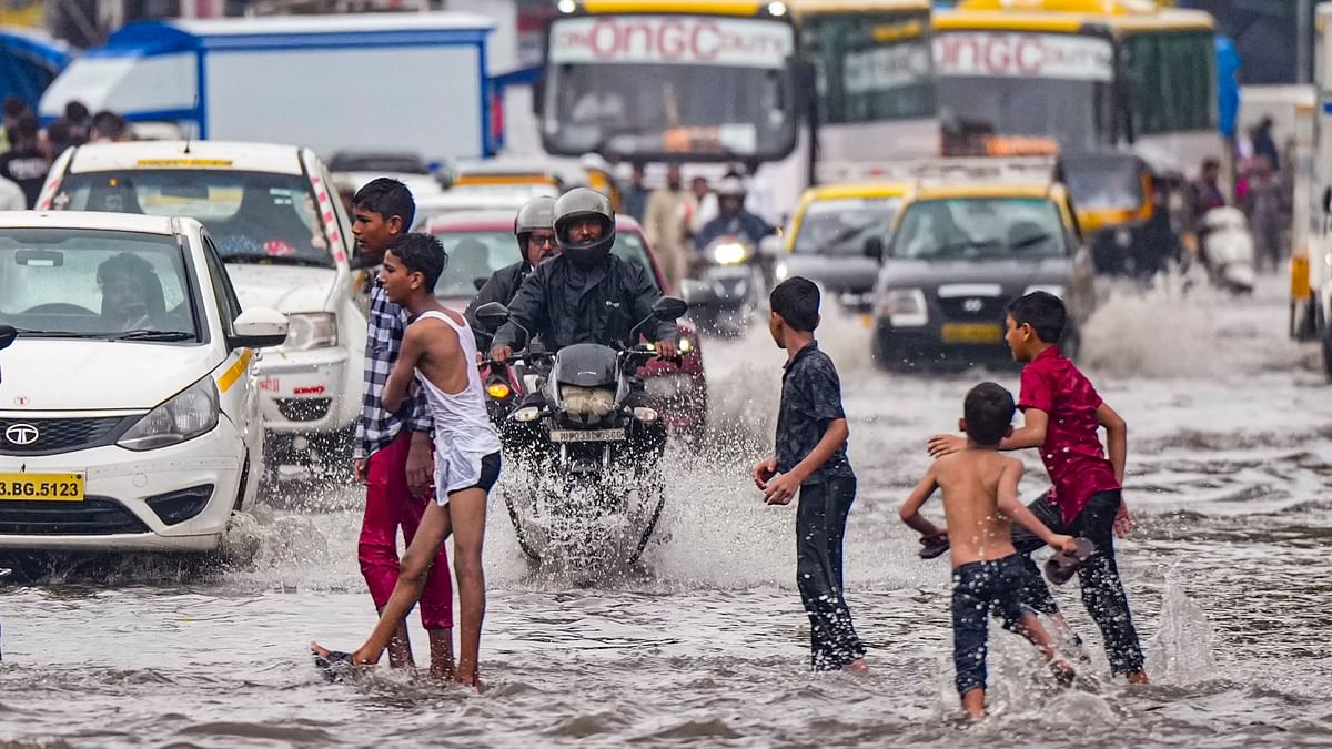 Children play in a waterlogged street in Mumbai