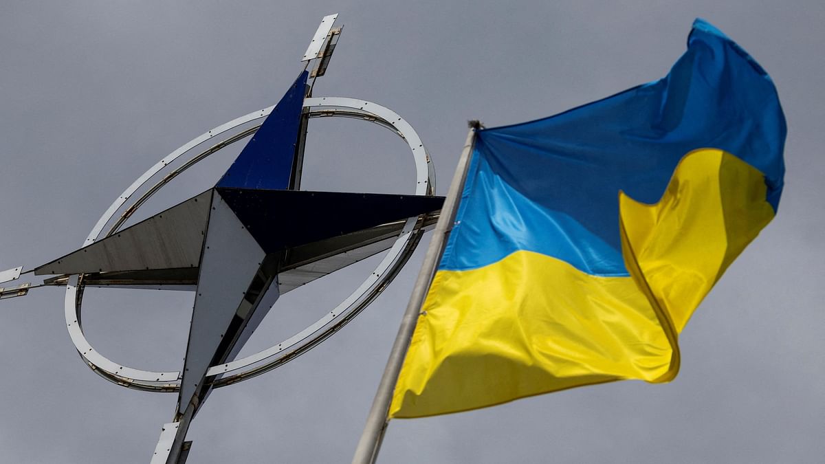 The Ukrainian national flag is pictured in front of the NATO emblem in central Kyiv.