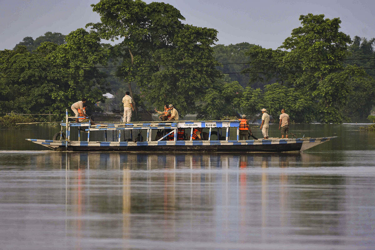 Forest guards patrol on a boat at Pobitora Wildlife Sanctuary during floods, in Morigaon district.