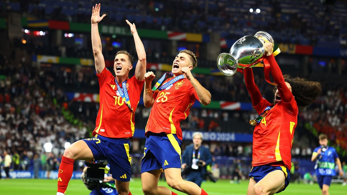 Spain's Dani Olmo, Marc Cucurella and Fermin Lopez celebrate with the trophy after winning the final.