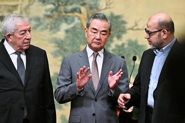 China's Foreign Minister Wang Yi hosts Vice Chairman of the Central Committee of Fatah, Mahmoud al-Aloul and senior member of Hamas, Mussa Abu Marzuk, at the Diaoyutai State Guesthouse in Beijing.