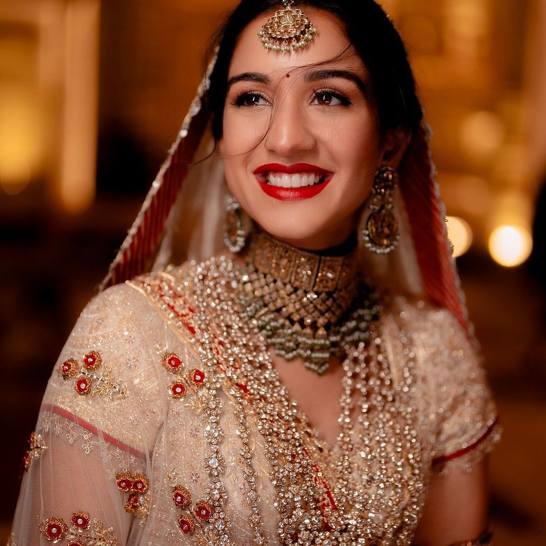 Her ensemble is Abu Sandeep’s intricate interpretation of ‘Panetar’ - the Gujarati tradition of brides wearing red and white.