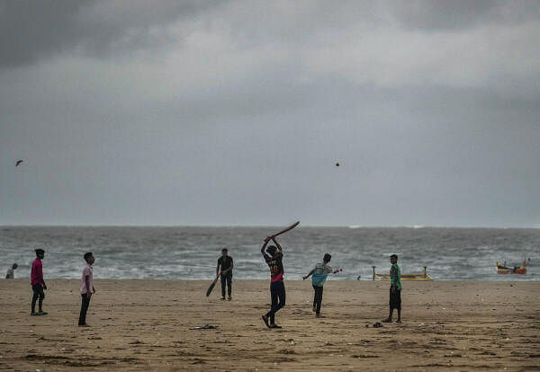 Youngsters play cricket on a beach in Mumbai on  July 9, 2024.