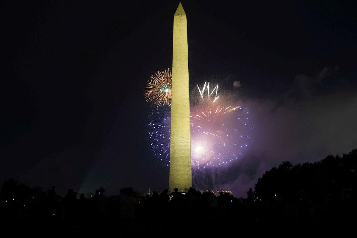 Spectators watch as fireworks explode near the Washington Monument during Fourth of July celebrations in Washington.