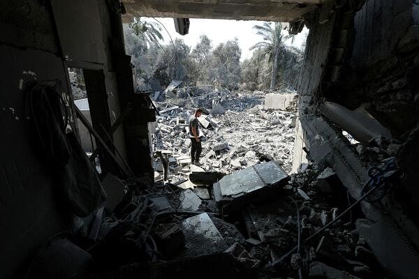 A Palestinian inspects a house destroyed in an Israeli strike amid the Israel-Hamas conflict, in Nusairat refugee camp, in the central Gaza Strip on July 9, 2024. 