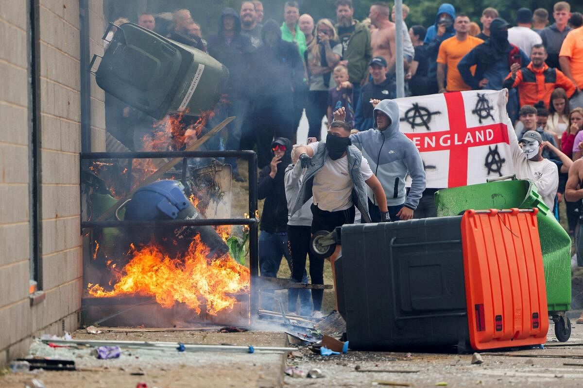 Protestors throw a garbage bin on fire outside a hotel in Rotherham, Britain, August 4, 2024.