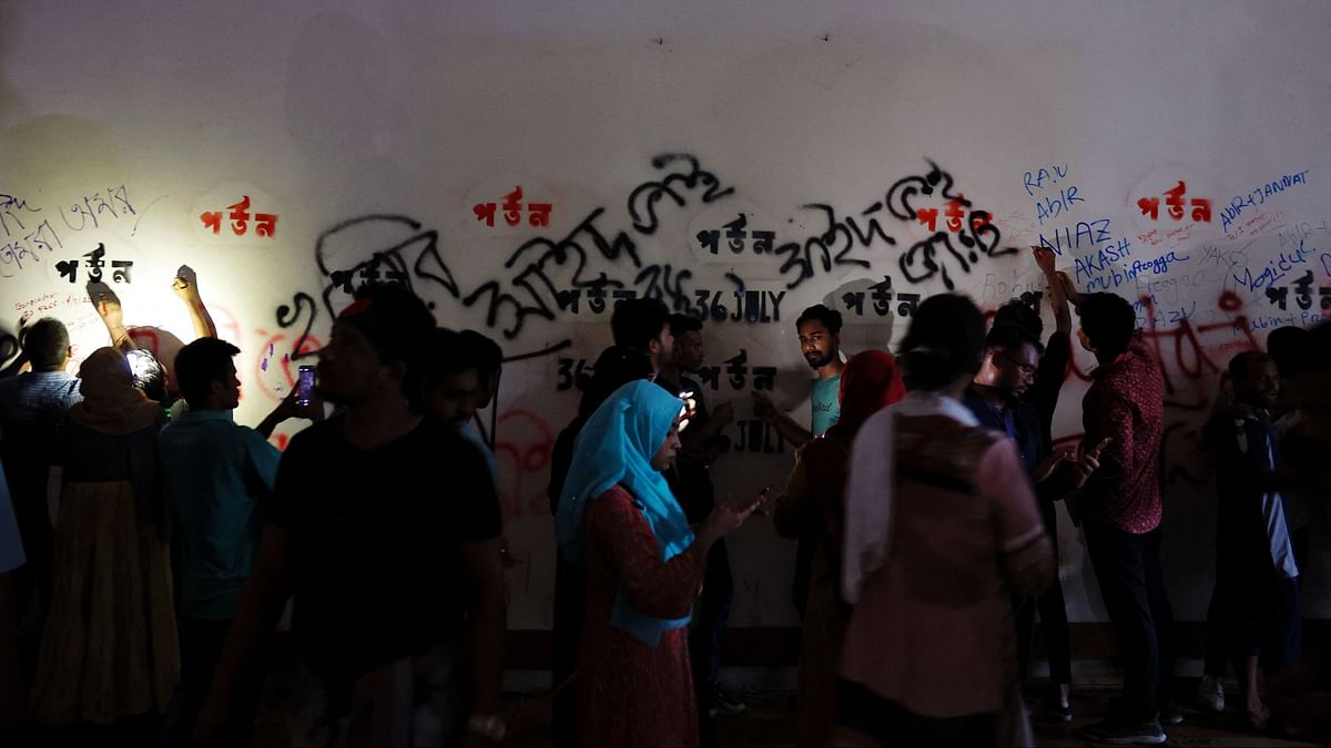 People write names of people who died during the protests on the wall of a room inside the Ganabhaban, the Prime Minister's residence, in Dhaka.