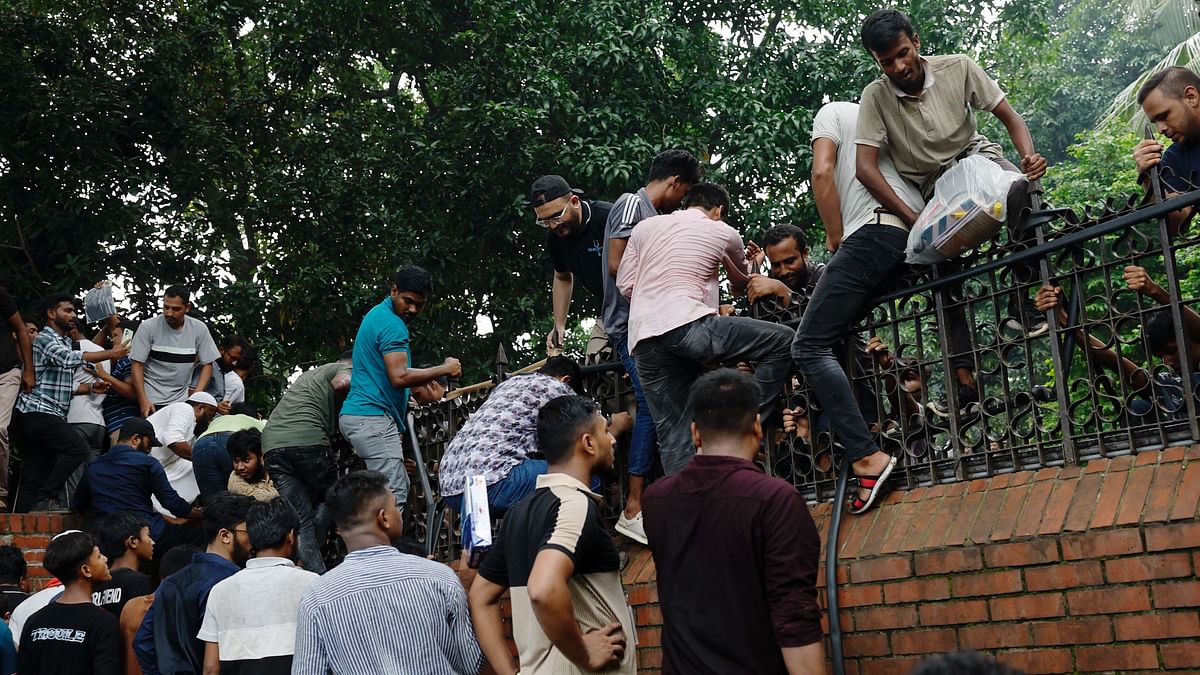 People climb the walls as they enter PM's official residence Ganabhaban, after the resignation of Sheikh Hasina in Dhaka, Bangladesh.