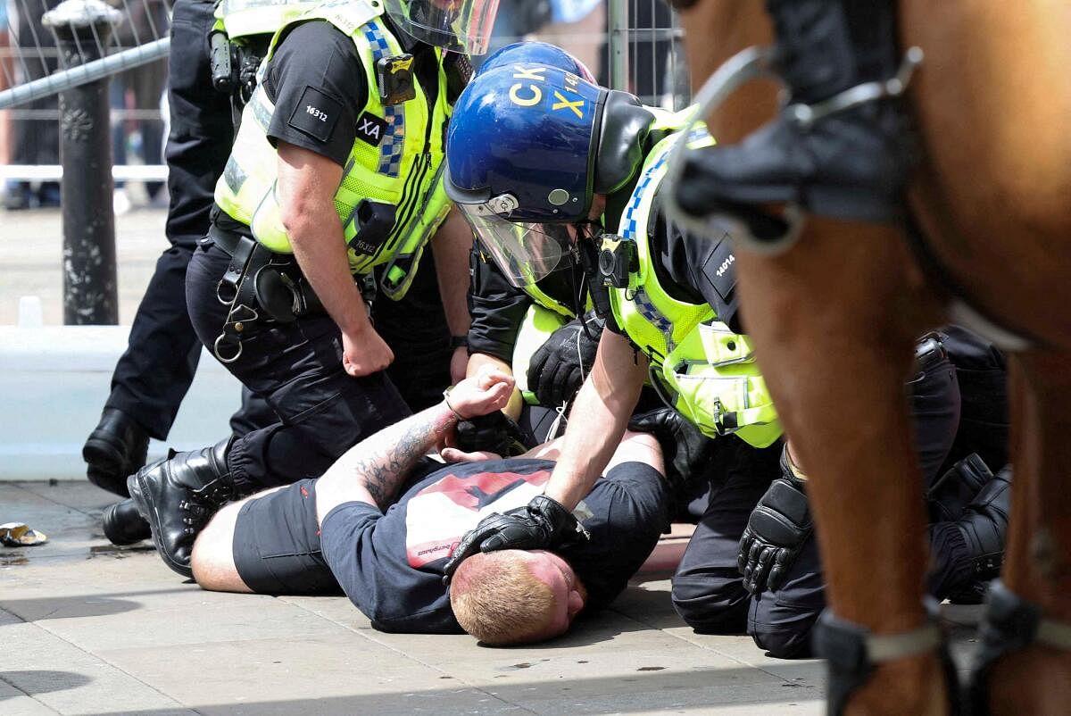 Police officers detain an anti-immigration demonstrator during a protest in Manchester, Britain, August 3, 2024.