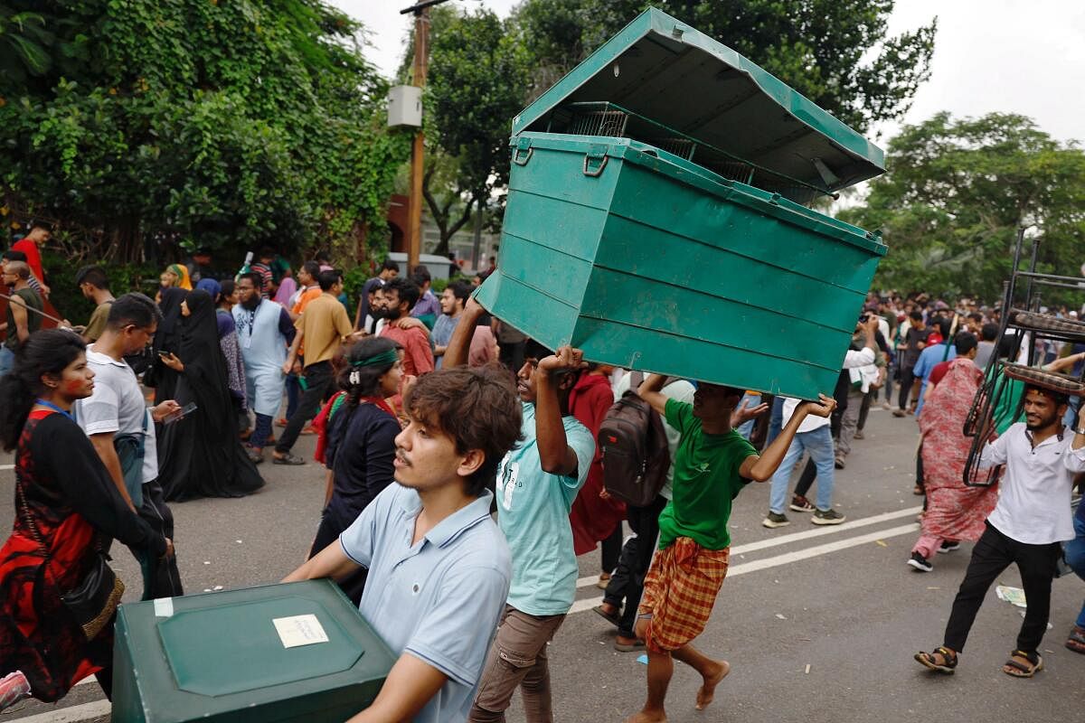 People loot a big metal box and other items from the Ganabhaban, the prime minister's residence, after the resignation of PM Sheikh Hasina in Dhaka, Bangladesh, August 5, 2024.