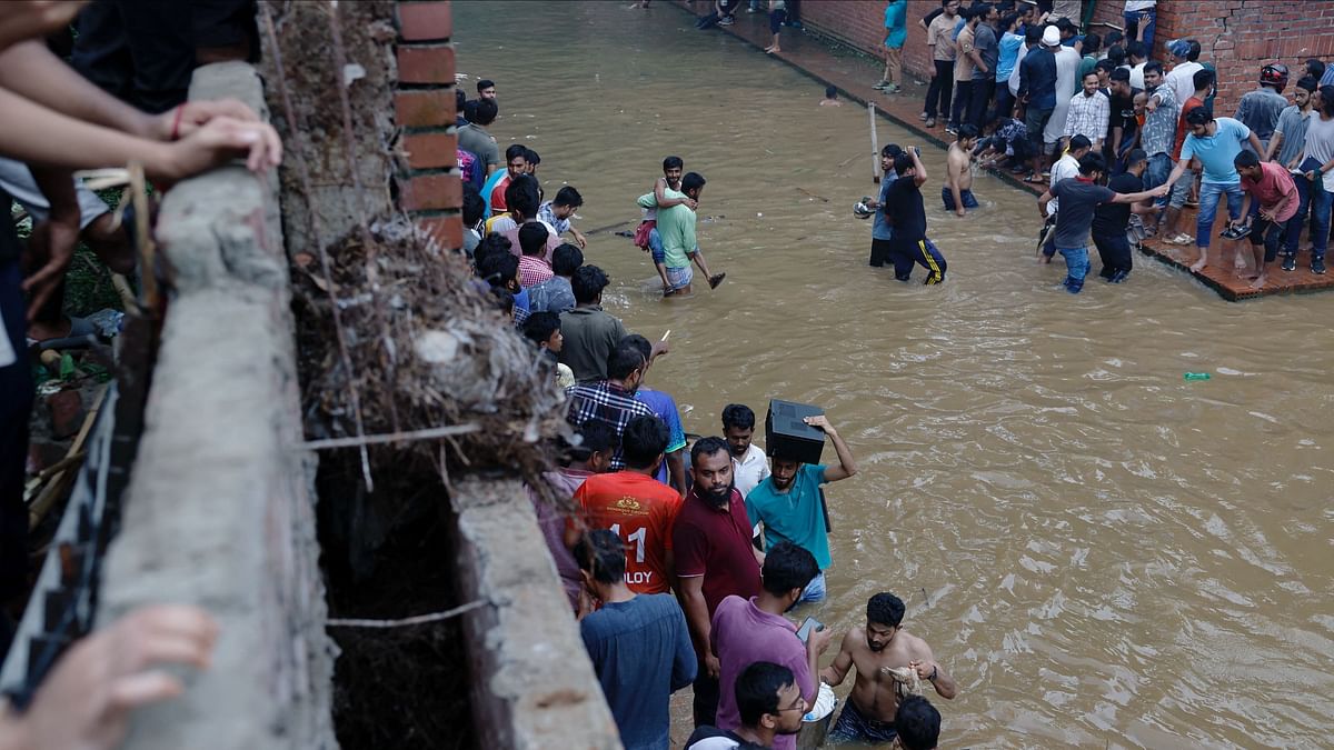 People leave after looting Hasina's official residence.