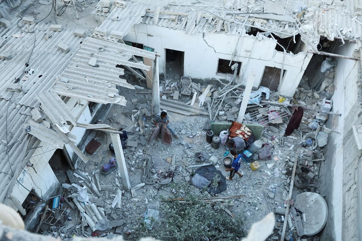 Palestinians inspect the site of an Israeli strike on a house, amid the Israel-Hamas conflict, in Deir Al-Balah in the central Gaza Strip, August 4, 2024.