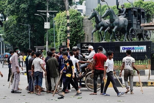 Demonstrators check a commuter during a protest demanding the stepping down of Bangladeshi Prime Minister Sheikh Hasina, following quota reform protests by students, in Dhaka, Bangladesh, August 4, 2024.