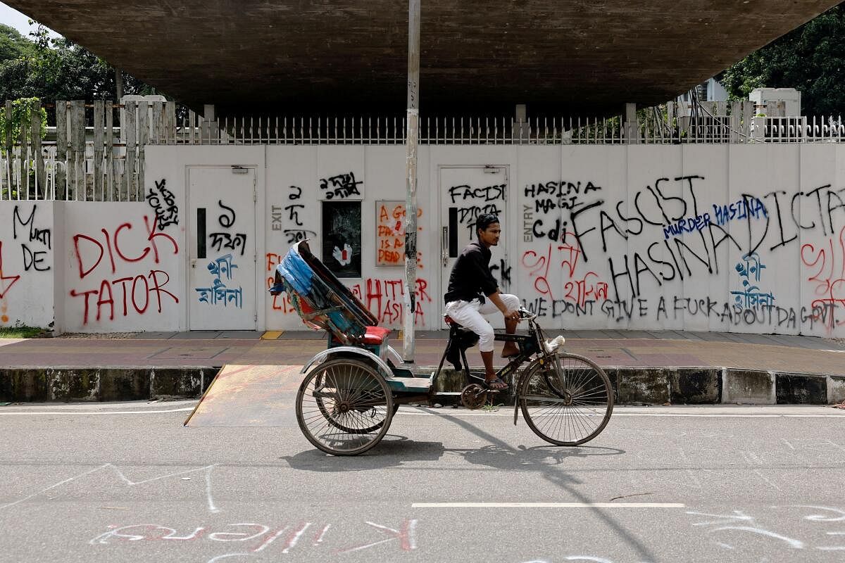 A rickshaw passes by a wall covered in graffiti in the University of Dhaka area, a day after the resignation of Bangladeshi Prime Minister Sheikh Hasina, in Dhaka, Bangladesh, August 6, 2024.